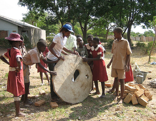 Annie Kanyemba, who trained the pupils to build toilets roles a concrete slab on to site.: Photograph by PRM